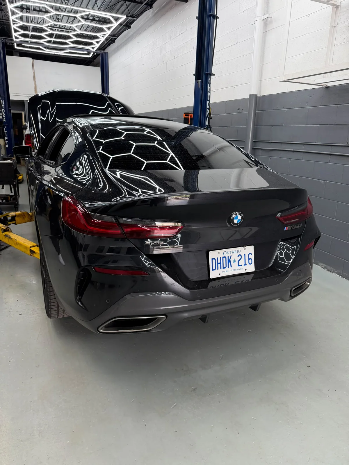 Black BMW being serviced inside Motorlux Auto Repairs
