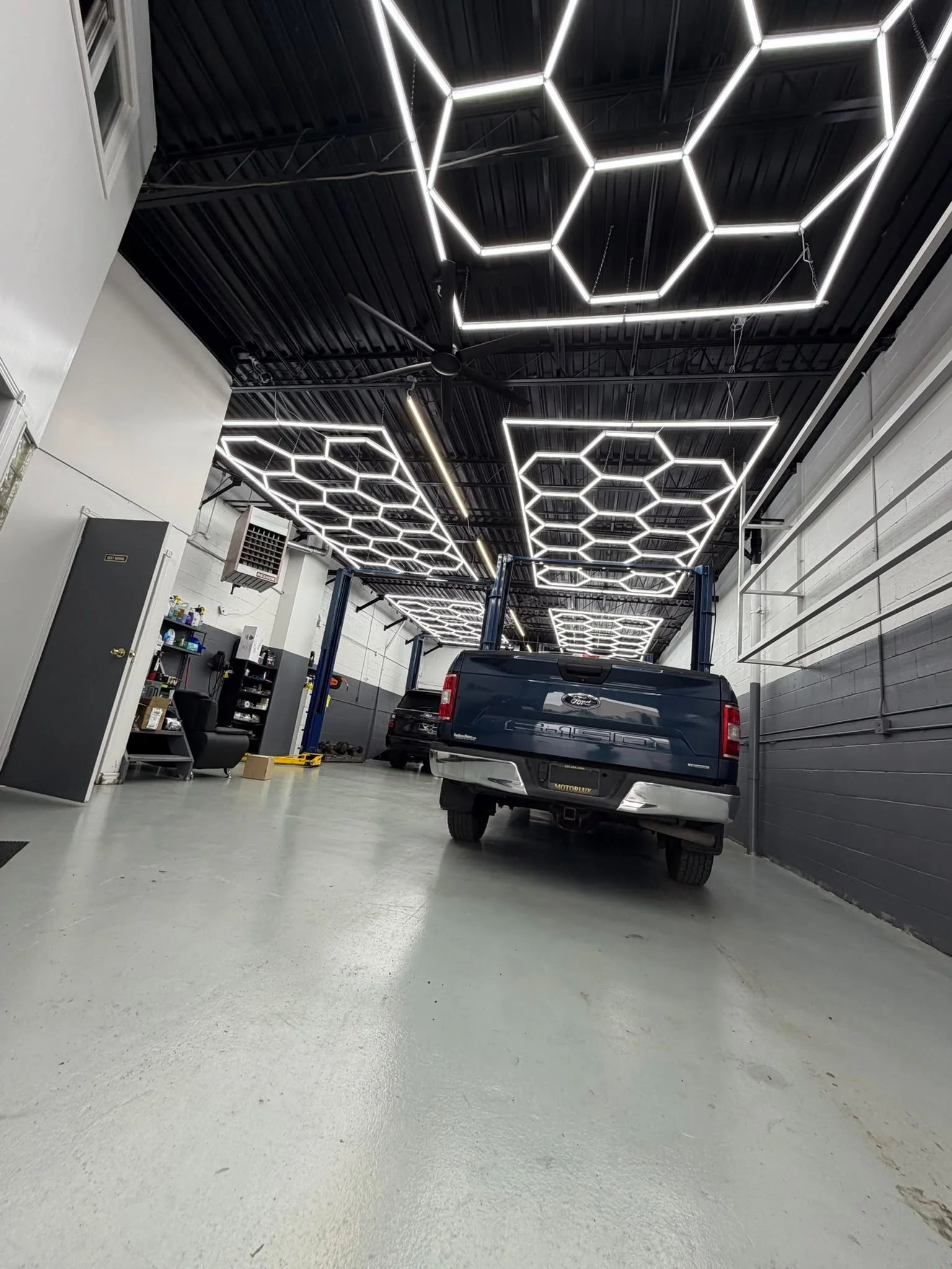 Clean Motorlux Auto Repairs shop interior with hexagon lighting